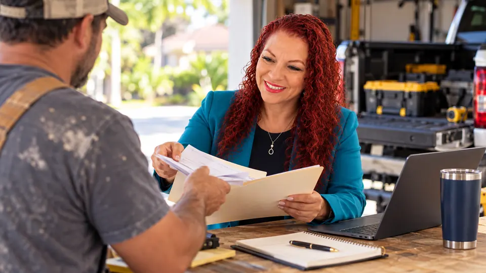 Iris sorting a contractor's receipts and mileage log at his Clearwater home