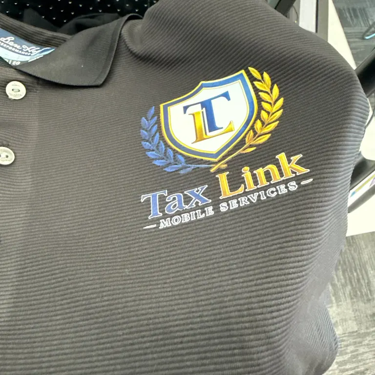 The embroidered Tax Link Mobile Services polo Iris wears to every in-home appointment